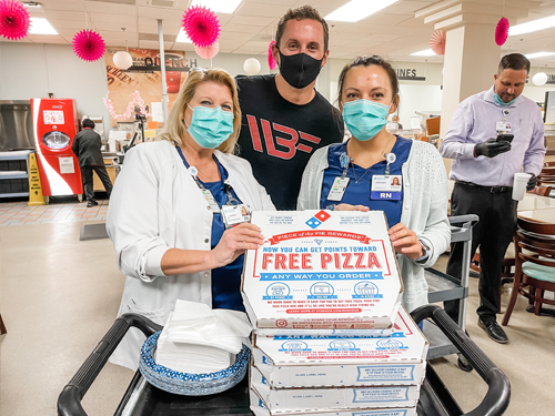 Photo of the firm's legal professional along with the staff members at Gulf Coast Regional Medical Center Pizza Day